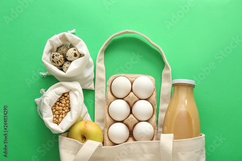 Cotton bags with fresh products on color background. Zero waste concept