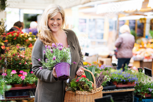 Attraktive, nett lachende Frau kauft Blumen auf dem Markt  photo