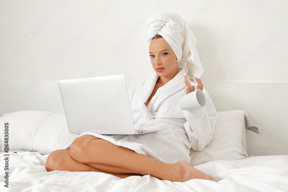 Waking up in a hotel, a young girl, a blogger, gladly does her job with a cup of freshly brewed coffee. Waking up in a hotel, a young girl, a blogger, gladly does her job with a cup of freshly brewed coffee.