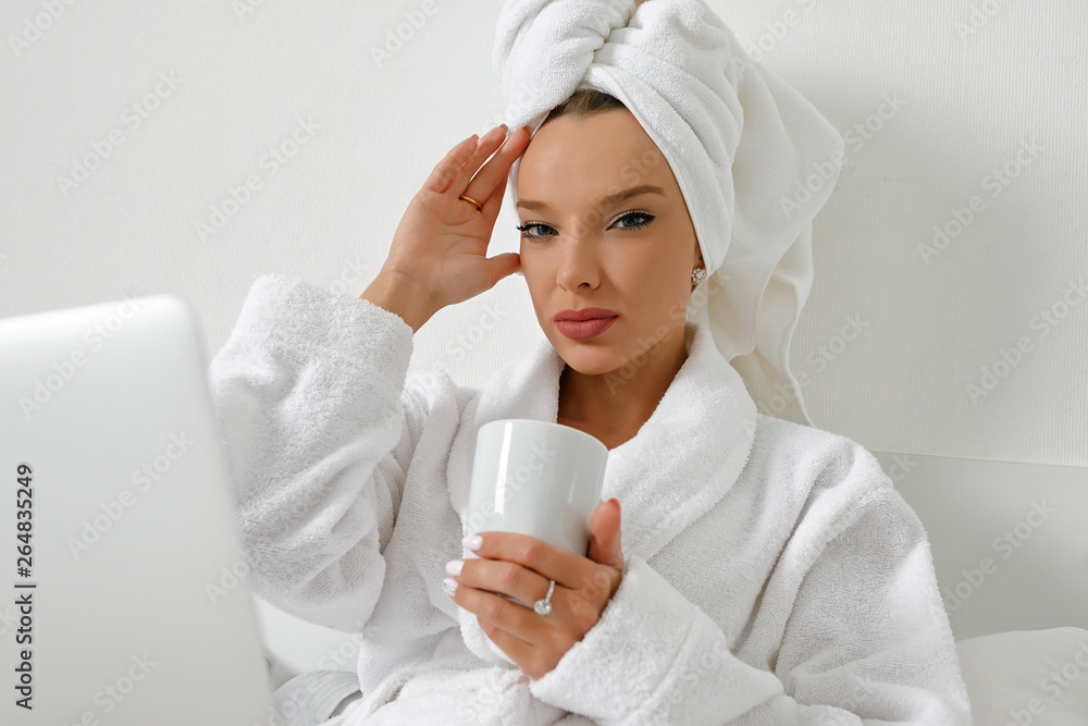 Waking up in a hotel, a young girl, a blogger, gladly does her job with a cup of freshly brewed coffee. Waking up in a hotel, a young girl, a blogger, gladly does her job with a cup of freshly brewed coffee.