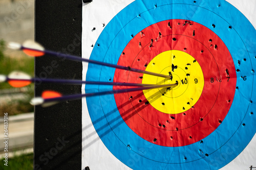 Photo Close up on three arrows in the middle center of the target goal achieved succes