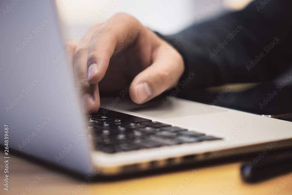 Closeup of man using laptop on workspace Closeup of man using laptop on workspace