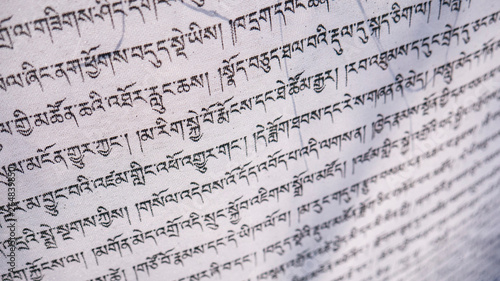 Tibetan letters on white textile. Religious writing. Prayer flags. Mantra. Buddhism. Calligraphy