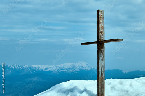 mountain cross with bit mountains in the background