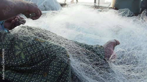 Fishermen repair their nets in front of the famed Chinese Nets in Fort Kochi, Kerala, India