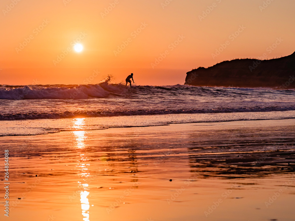 Surfer enjoying a beautiful sunset surf at Montanita Ecuador