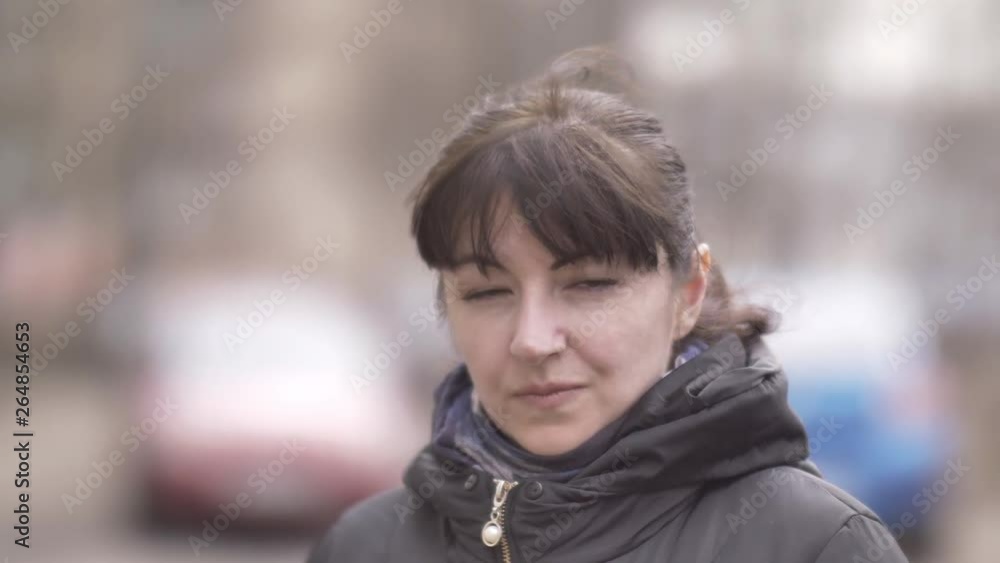 portrait of a woman standing on the street and looking at the camera in autumn portrait of a woman standing on the street and looking at the camera in autumn