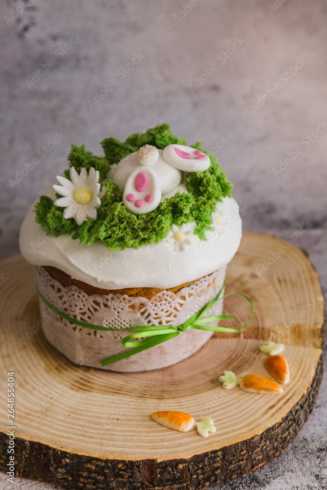 Easter Cakes decorated with a hare dives into a hole on wooden plate - Traditional Kulich, Paska Easter Bread Easter Cakes decorated with a hare dives into a hole on wooden plate - Traditional Kulich, Paska Easter Bread