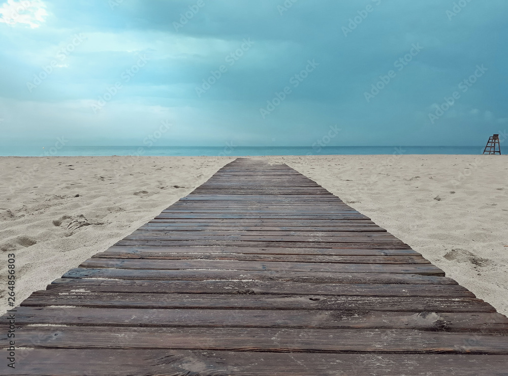 Wooden walkway leading from the beach to the sea with an intense blue sky. Wooden walkway leading from the beach to the sea with an intense blue sky.