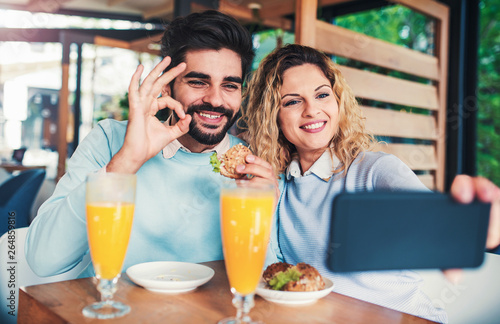 Beautiful young couple sitting in a cafe, having breakfast. Love, dating, food, lifestyle concept