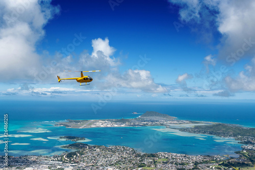 Aerial view of helicopter from high a ridge trail on Oahu, Hawaii overlooking Kaneohe, Kailua and the windward side of the island