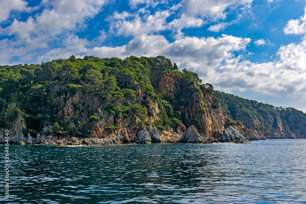 Scenery rocky seascape in spanish Mediterranean sea coast. Scenic rocks in clear turquoise sea water. Blanes, Costa Brava, Spain.