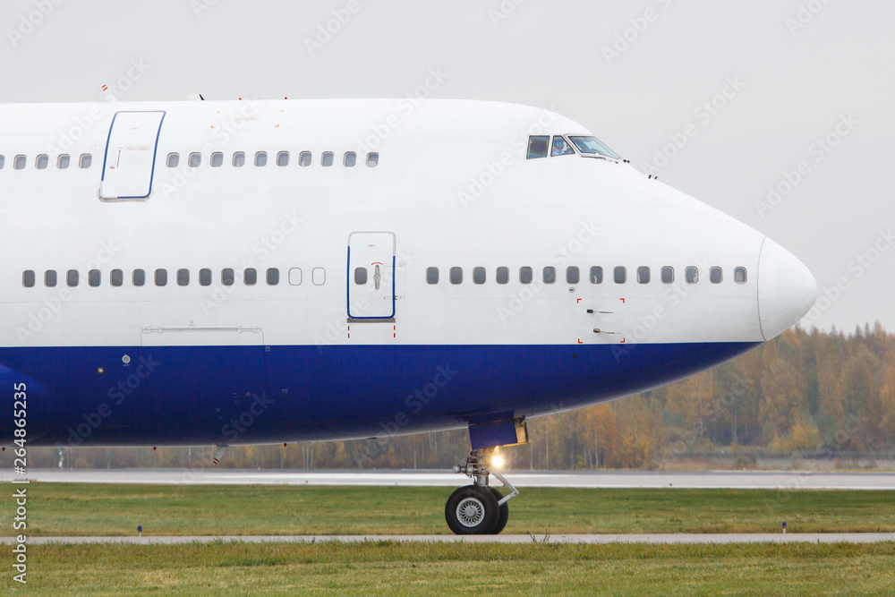Modern passenger double-decker airplane is taxiing to take off.  Wide-body aircraft on runway, close up, side view. Vacation, aviation, travel concept