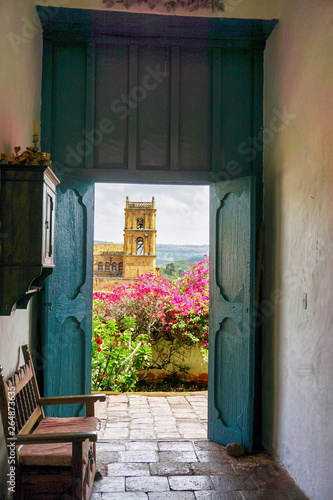 Church of Barichara framed by the door of old colonial house in Satander, Colombia.