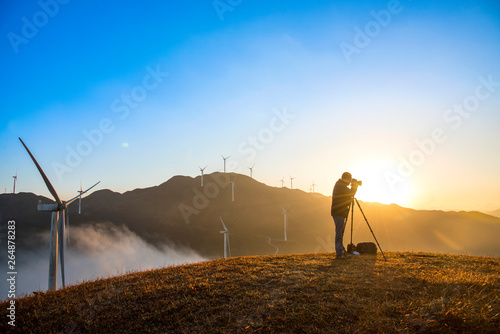 Photographers in the mountain wind turbines and sunrise and sunset cloud background