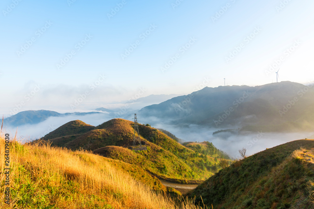 The mountain wind turbines in the sunrise and sunset in the sea of clouds