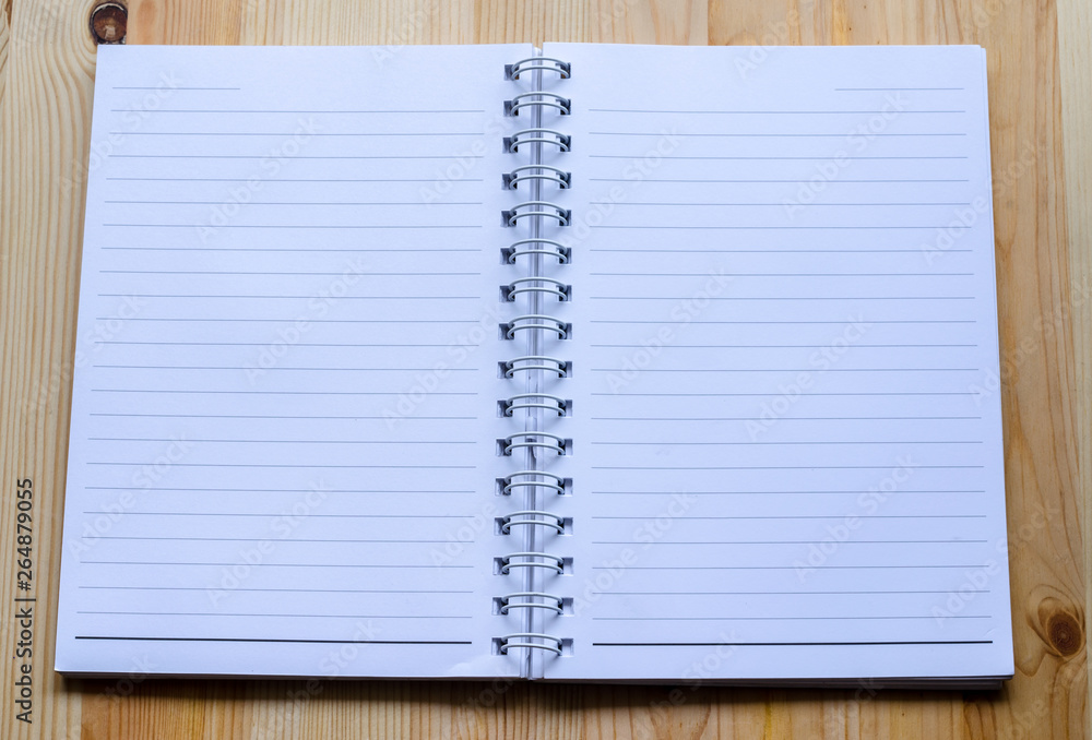 Note book paper on wooden background Note book paper on wooden background
