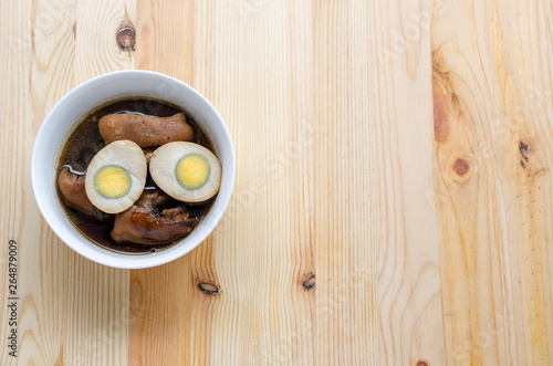 Egg and pork in brown sauce on wooden background, Thai Cuisine
