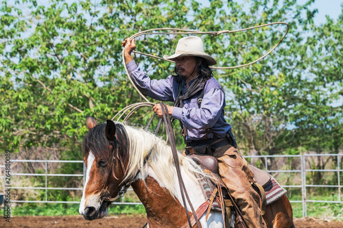 A man in a cowboy outfit with his horse