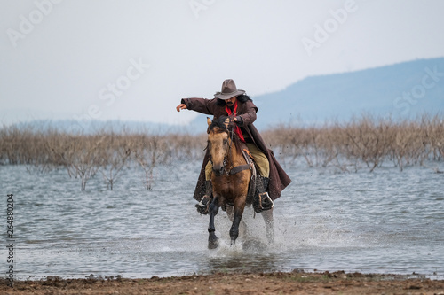 A man in a cowboy outfit with his horse