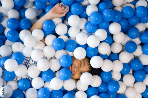 Little boy playing ball pool at playground