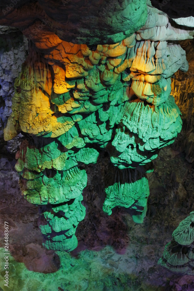 beautiful illuminated multicolored stalactites from karst Reed Flute cave In the cave. Guilin Guangxi China beautiful illuminated multicolored stalactites from karst Reed Flute cave In the cave. Guilin Guangxi China