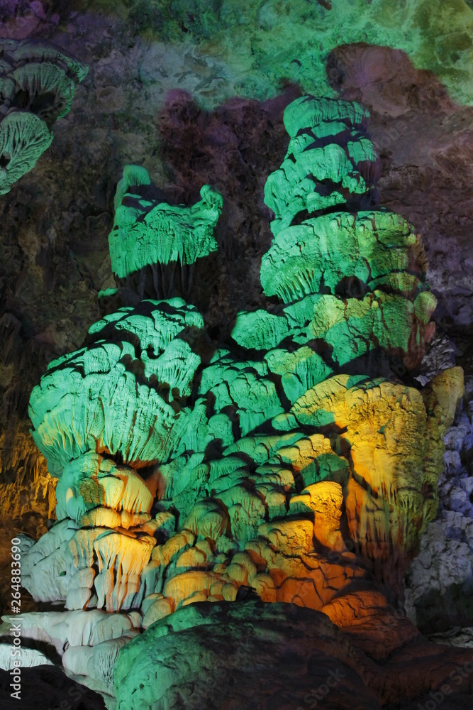 beautiful illuminated multicolored stalactites from karst Reed Flute cave In the cave. Guilin Guangxi China beautiful illuminated multicolored stalactites from karst Reed Flute cave In the cave. Guilin Guangxi China