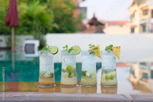 pineapple mojito cocktail and lime mojito cocktail at swim pool background © WS Studio 1985