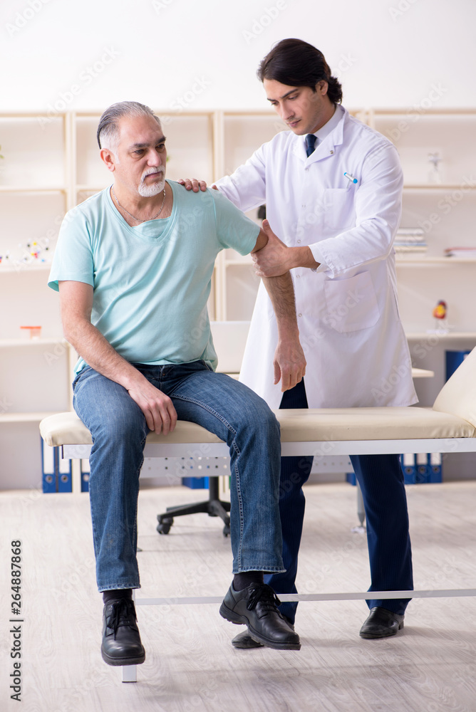 Fototapeta premium Old man visiting young male doctor 