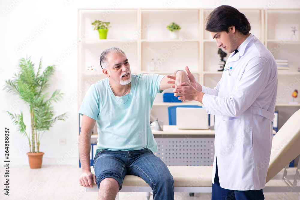 Old man visiting young male doctor Old man visiting young male doctor
