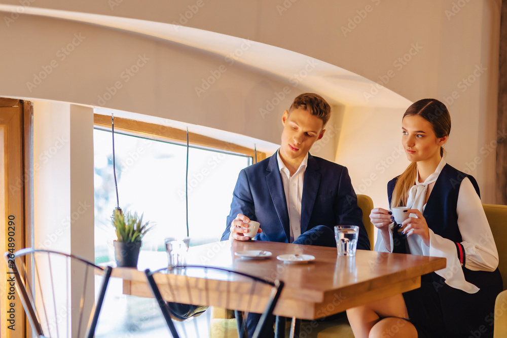 A stylish couple drinks morning coffee at the cafe, young businessmen and freelancers A stylish couple drinks morning coffee at the cafe, young businessmen and freelancers