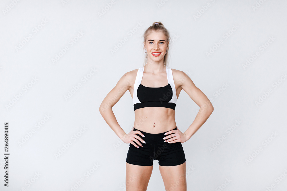 Portrait of fit and sporty young woman doing stretching on gray. Portrait of fit and sporty young woman doing stretching on gray.