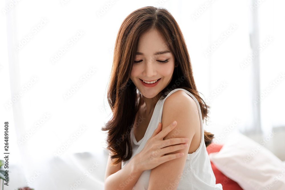 Beautiful woman beauty health care.beauty and spa.perfect fresh skin.woman touch her arm on the bed at home Beautiful woman beauty health care.beauty and spa.perfect fresh skin.woman touch her arm on the bed at home