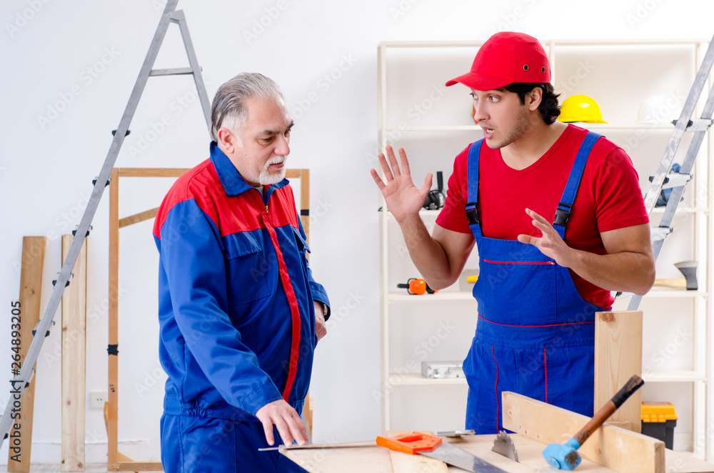 Two professional contractors laying flooring at home Two professional contractors laying flooring at home