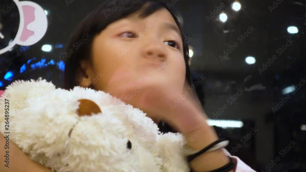 Asian girl hugging a white teddy bear is talking Asian girl hugging a white teddy bear is talking