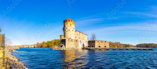 Beautiful view of Olavinlinna, Olofsborg ancient fortress, the 15th-century medieval three - tower castle located in Savonlinna city on a sunny May day. lake Saimaa, Finland. photo