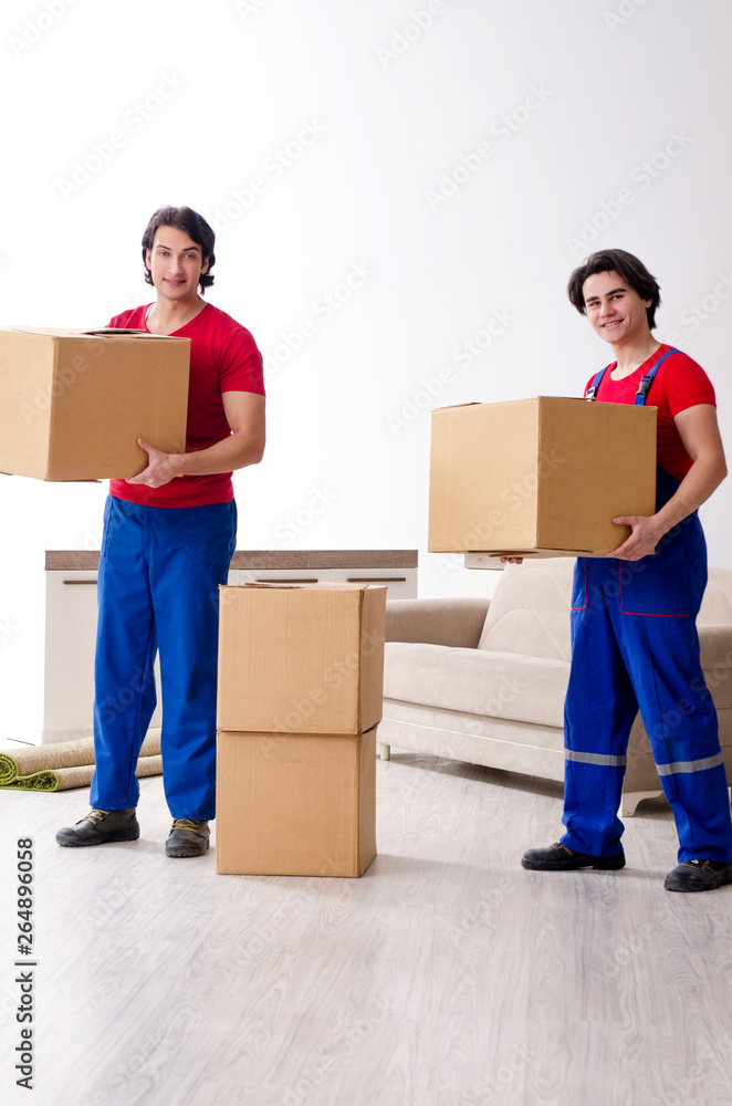 Two young contractor employees moving personal belongings Two young contractor employees moving personal belongings