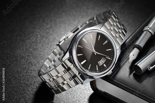 Steel wristwatch on black background photo