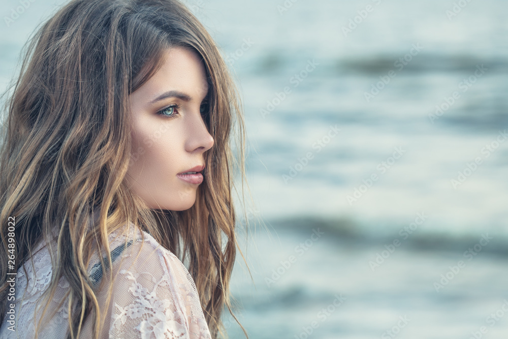 Beautiful female profile. Perfect woman with curly hair on blue ocean background Beautiful female profile. Perfect woman with curly hair on blue ocean background