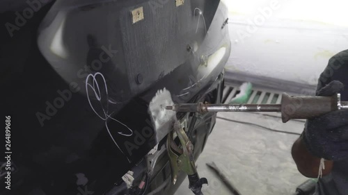 Mechanic worker repairman fixing by sanding polishing car body and preparing for painting at station service. Worker repairing car body