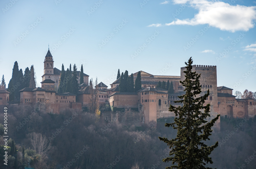 View of Alhambra Palace in Granada, Spain with Sierra Nevada mountains in snow at the background . Granada, Spain.