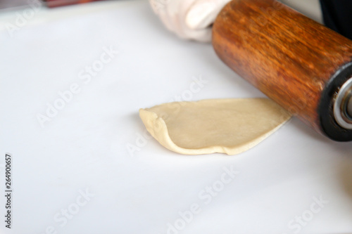 Step by step, baker prepares bread. baker slaps on dough. making bread, hand with rolling pin and flour, hands rolling out dough, baking dough with rolling pin