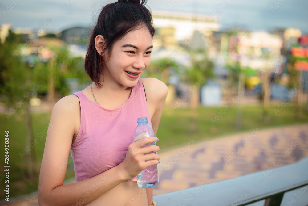 Asian woman showing a bottle of water Asian woman showing a bottle of water