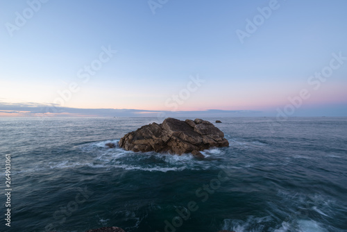 Großer Felsen im Meer bei Sonnenuntergang, Frankreich, Bretagne, Finistere 