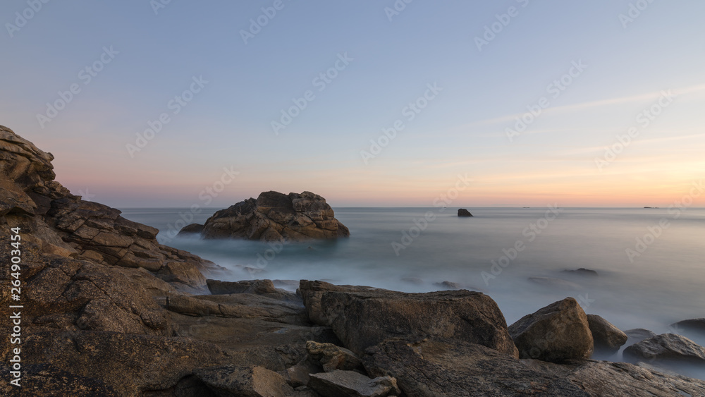 Langzeitbelichtung des Sonnenaufgangs an der felsigen bretonischen Küste in Frankreich, Bretagne, Finistere