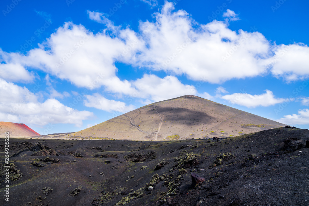 Spain, Lanzarote, Dry lava field surrounding huge volcanic mounts in caldera landscape near el cuervo volcano