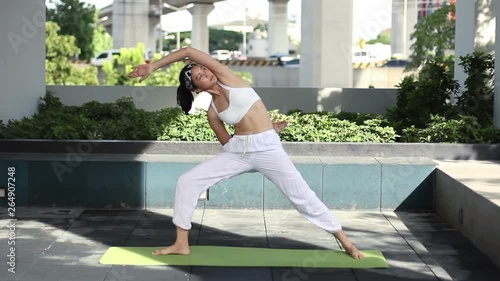 beautigul asian girl yoga and stretching outdoor with background city and swimming pool