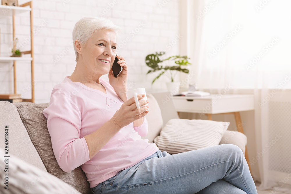 Cheerful senior lady having phone call on her smartphone Cheerful senior lady having phone call on her smartphone