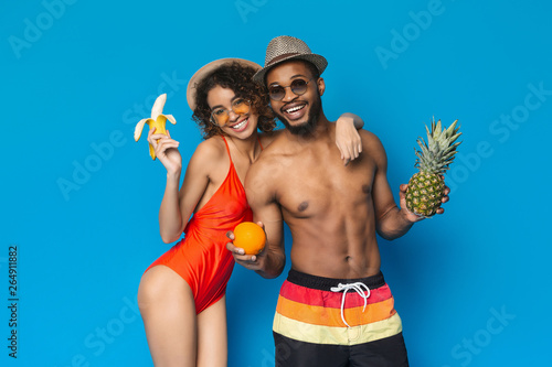 Cute african american couple enjoying summer fruits and smiling