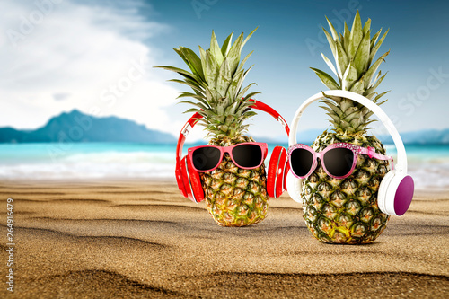 Summer photo of beach and fresh pineapple on sand 
